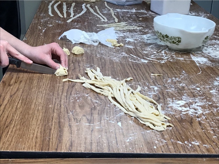 A seventh grader cutting her pasta