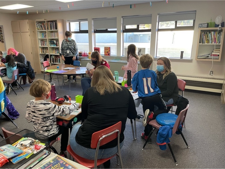students and their families work at desks
