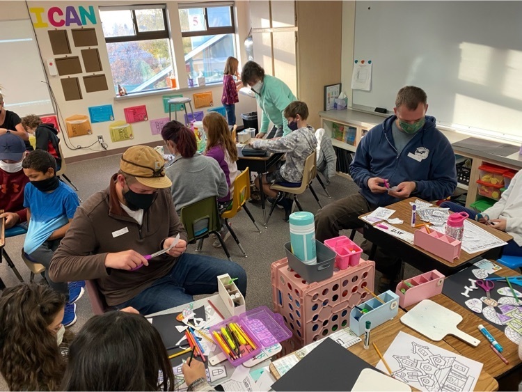 students and their families work at desks